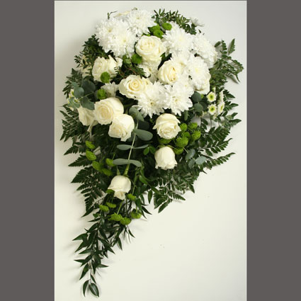 Flowers in Riga. Funeral flower arrangement of white roses, white and green chrysanthemums and decorative foliage.