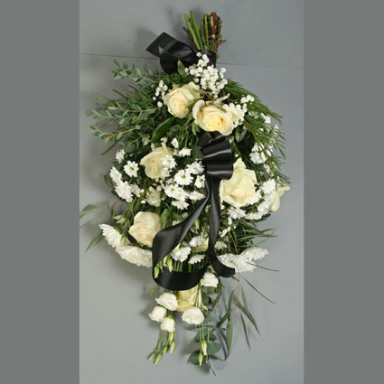 Flowers delivery. Funeral bouquet of white roses, white lisianthus, white chrysanthemums, babys-breath and eucalyptus.