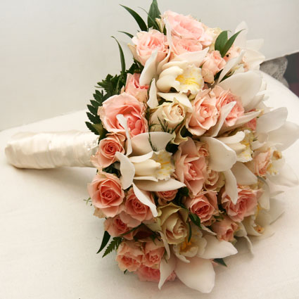Ziedu veikals. Līgavas pušķis pasteļtoņos no gaiši rozā krūmu rozītēm un baltiem orhideju ziediem.

Kāzas ir īpašs