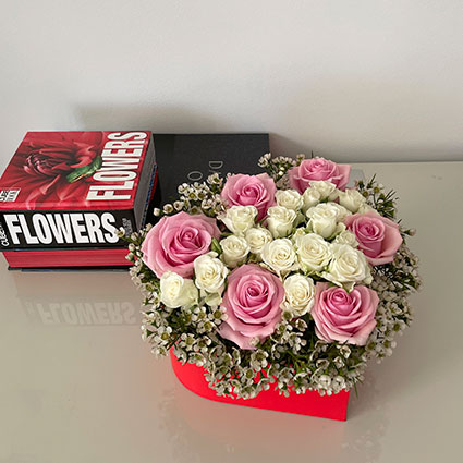 Arrangement of pink and white roses in a heart-shaped box