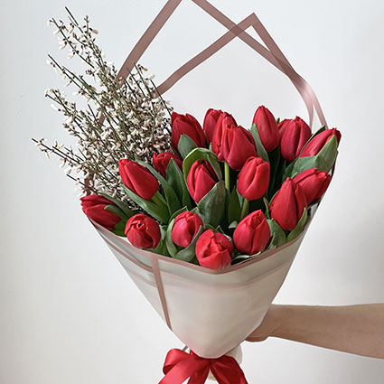 Piegāde Sieviešu dienā, Pavasarīgā ziedu pušķī sarkanas tulpes un balti smalkziedi dekoratīvā saiņojumā