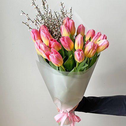 Piegāde Sieviešu dienā, Pavasarīgā ziedu pušķī rozā tulpes un balti smalkziedi dekoratīvā saiņojumā