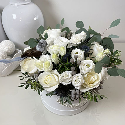 В цветочной коробке белые розы, белый лизиантус и декор птичка