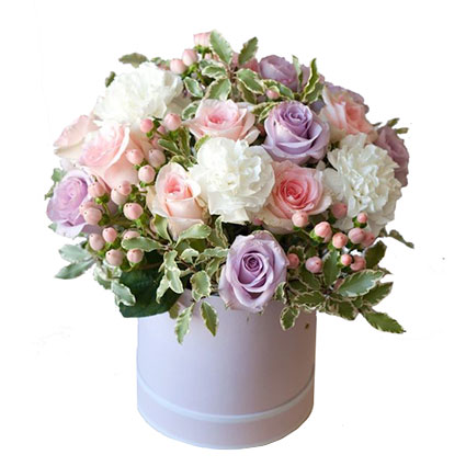 Arrangement of pink and purple roses, white carnations and decorative foliage in a flower box