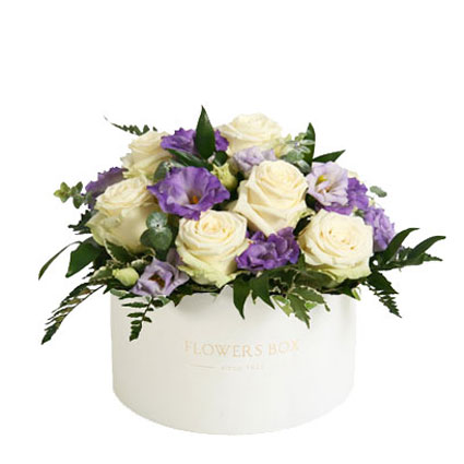 Flowers delivery. Arrangement of white roses, blue lisianthus and decorative foliage in a flower box.