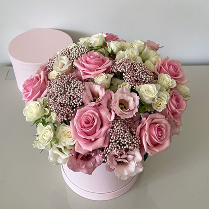 Ziedu kastītē rozā rozes, baltas rozes, rozā lizantes un dekoratīvi smalkziedi