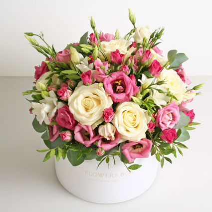 Ziedu piegāde Rīgā, ziedu kārbā baltas un rozā rozes, rozā lizantes, baltas frēzijas un dekoratīvi zaļumi 30 cm garumā
