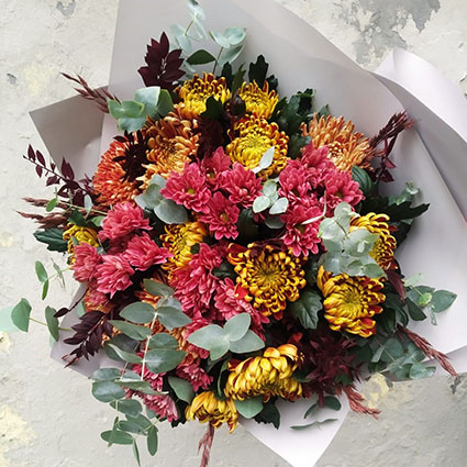 Bouquet  of chrysanthemums in autumn colors with decorative seasonal foliage
