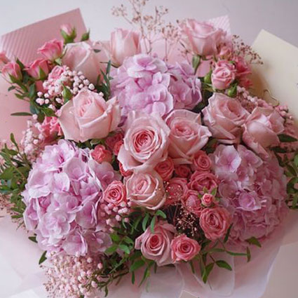 Ziedu pušķis rozā toņos no hortenzijām un rozēm