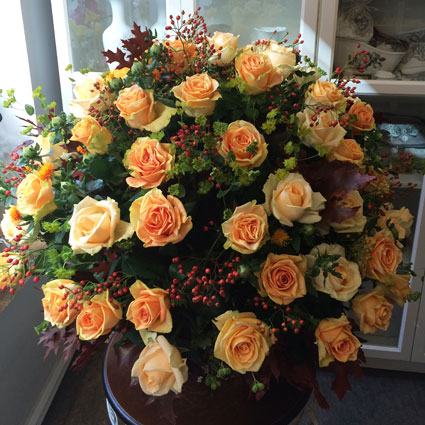 Ziedu piegāde Rīgā, apjomīgā pušķī krēmkrāsas rozes, dekoratīvas ogas un sezonas zaļumi